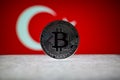Physical silver version of Bitcoin BTC and Turkey Flag on the background. Conceptual image for investors in