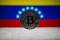 Physical silver version of Bitcoin BTC and Venezuela Flag on the background. Conceptual image for investors in