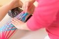 Physical therapist applying kinesio tape on female patient`s calf. Kinesiology, physical therapy, rehabilitation concept. Close up Royalty Free Stock Photo