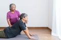 Physical therapist Asian woman, doing back and lumbar physiotherapy for elderly man Royalty Free Stock Photo