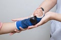 Physical therapist assisting patient woman in lifting dumbbells