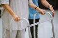 Physical therapist helping senior patient in using walker during rehabilitation Royalty Free Stock Photo