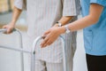 physical therapist helping senior patient in using walker during rehabilitation Royalty Free Stock Photo