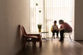 A physical therapist or nurse is talking to and caring for a young child with multiple disabilities in the clinic, rehabilitation