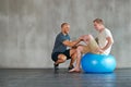 Physical therapy, happy and gym ball with a man with disability and physio advice for rehabilitation. Physiotherapy Royalty Free Stock Photo