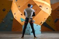 Physically challenged boulderer standing in front of artificial climbing wall