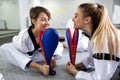 Physically disabled martial art combat fighter and her friend holding a kick pad target