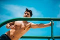 Physically fit man exercising outdoors doing triceps dips on parallel bars Royalty Free Stock Photo