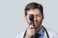 Physician with beard using ophthalmoscope