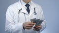 Physician counting bundle of money, expensive medicine at private clinic, bribe