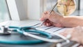 Physician doctor writing on medical health care record, patients discharge, or prescription form paperwork in hospital clinic Royalty Free Stock Photo