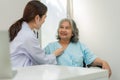 Physician examining heart with a stethoscope and talking with a senior woman at a clinic for check yearly checkup, Medicine health