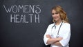 Physician standing near Womens health inscription, annual physical examination