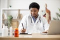 Physician typing on laptop and making notes in clinic Royalty Free Stock Photo