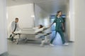 Physicians Moving Patient On Gurney Through Hospital Corridor