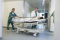 Physicians Moving Patient On Gurney Through Hospital Corridor Royalty Free Stock Photo