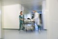 Physicians Moving Patient On Gurney Through Hospital Corridor