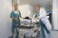 Physicians Moving Patient On Gurney Through Hospital Corridor Royalty Free Stock Photo