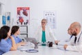 Physicians teamwork in white coats working at healthcare medical expertise in conference meeting room