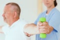 Physiotherapist assisting a patient performing weight exercises Royalty Free Stock Photo