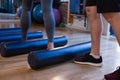 Physiotherapist assisting senior woman in performing exercise on foam roll Royalty Free Stock Photo