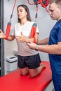 Physiotherapist assists female patient at a modern fitness center. Royalty Free Stock Photo