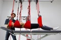 Physiotherapist assists female patient undergoing rehabilitative physiotherapy on a suspension rope system. Royalty Free Stock Photo