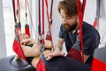 Physiotherapist assists female patient undergoing rehabilitative physiotherapy on a suspension rope system. Royalty Free Stock Photo