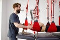 Physiotherapist assists female patient undergoing rehabilitative physiotherapy on a suspension rope system. Royalty Free Stock Photo