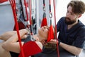 Physiotherapist assists female patient undergoing rehabilitative physiotherapy on a suspension rope system. Royalty Free Stock Photo