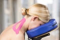 Physiotherapist, chiropractor putting on pink kinesio tape on woman patient. Cervical Royalty Free Stock Photo