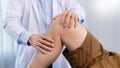 Physiotherapist doctor rehabilitation consulting physiotherapy giving exercising knee treatment with patient in physio clinic or