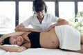 Physiotherapist doing belly massage to beautiful pregnant woman in spa center Royalty Free Stock Photo