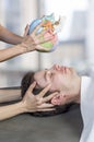 Physiotherapist doing a cranial sacral therapy to a man patient