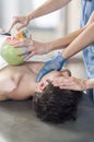 Physiotherapist is doing intraoral technique of massage masseter muscle and another physiotherapist with a fake skull showing p