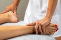 Physiotherapist doing treatment on female feet.