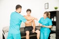 Physiotherapist Examining Shirtless Customer`s Hand While Cowork