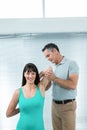 Physiotherapist guiding pregnant woman with exercise Royalty Free Stock Photo