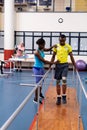 Physiotherapist helping disabled man walk with parallel bars in sports center Royalty Free Stock Photo