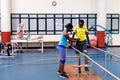Physiotherapist helping disabled man walk with parallel bars in sports center Royalty Free Stock Photo
