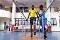 Physiotherapist helping disabled man walk with parallel bars in sports center Royalty Free Stock Photo