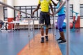 Physiotherapist helping disabled man walk with parallel bars in sports center Royalty Free Stock Photo