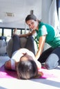 Physiotherapist helping to beautiful pregnant woman for doing pilates exercises with ball preparing for childbirth