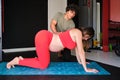 Physiotherapist help to pregnant woman doing Pilates childbirth preparation.