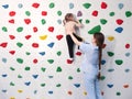 physiotherapist instructor helping little girl to climb wall in gym. sensory integration for kid and correctional Royalty Free Stock Photo