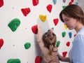 physiotherapist instructor helping little girl to climb wall in gym. sensory integration for kid and correctional Royalty Free Stock Photo