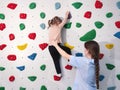 physiotherapist instructor helping little girl to climb wall in gym. sensory integration for kid and correctional Royalty Free Stock Photo