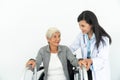 Physiotherapist Looking At Senior Patient Sitting In Wheelchair, doctor and patient on wheelchair Royalty Free Stock Photo