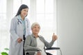 Physiotherapist Looking At Senior Patient Sitting In Wheelchair, doctor and patient on wheelchair Royalty Free Stock Photo