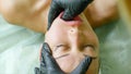 Physiotherapist is making facial massage working on woman`s jaw in beauty clinic